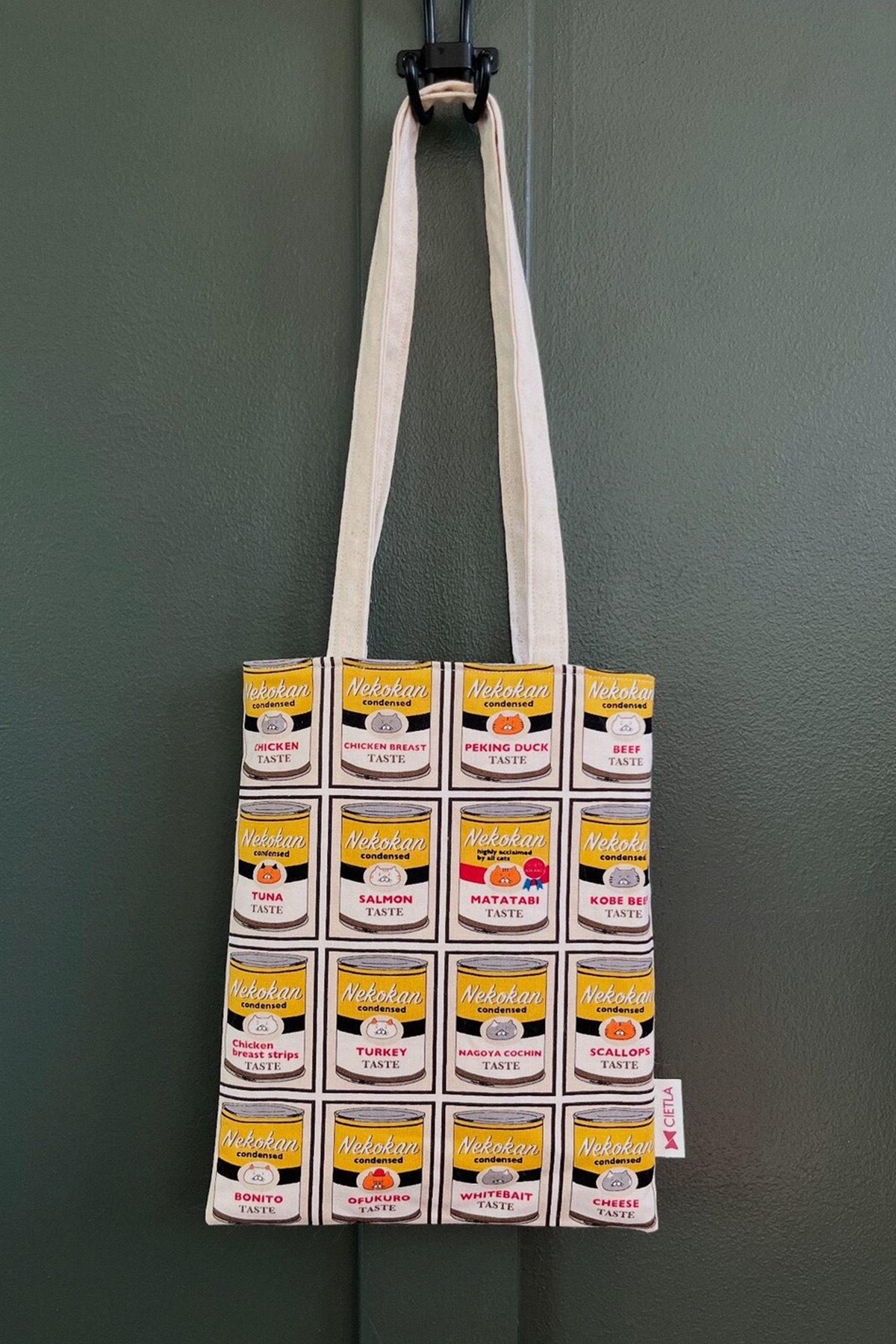 CIETLA Nekokan Cat Condensed Tote Bag (Yellow) hanging on wall